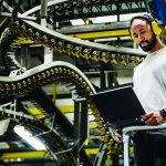 Print Factory Engineer Working Alongside Moving Machinery