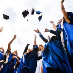 15814393 – image of happy young graduates throwing hats in the air