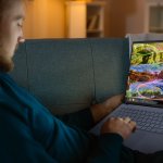 Man,Sitting,Relaxes,On,A,Couch,Works,On,A,Laptop