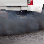Air pollution from vehicle exhaust pipe on road