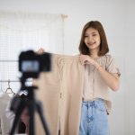 Young Asian seller girl showing woman clothes and making video l