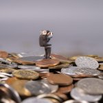 Photographer stands on a pile of coins capturing a moment